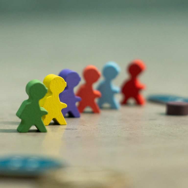 Meeple Bunte Spielfiguren in einer Reihe, mit verschiedenen Farben und Formen.